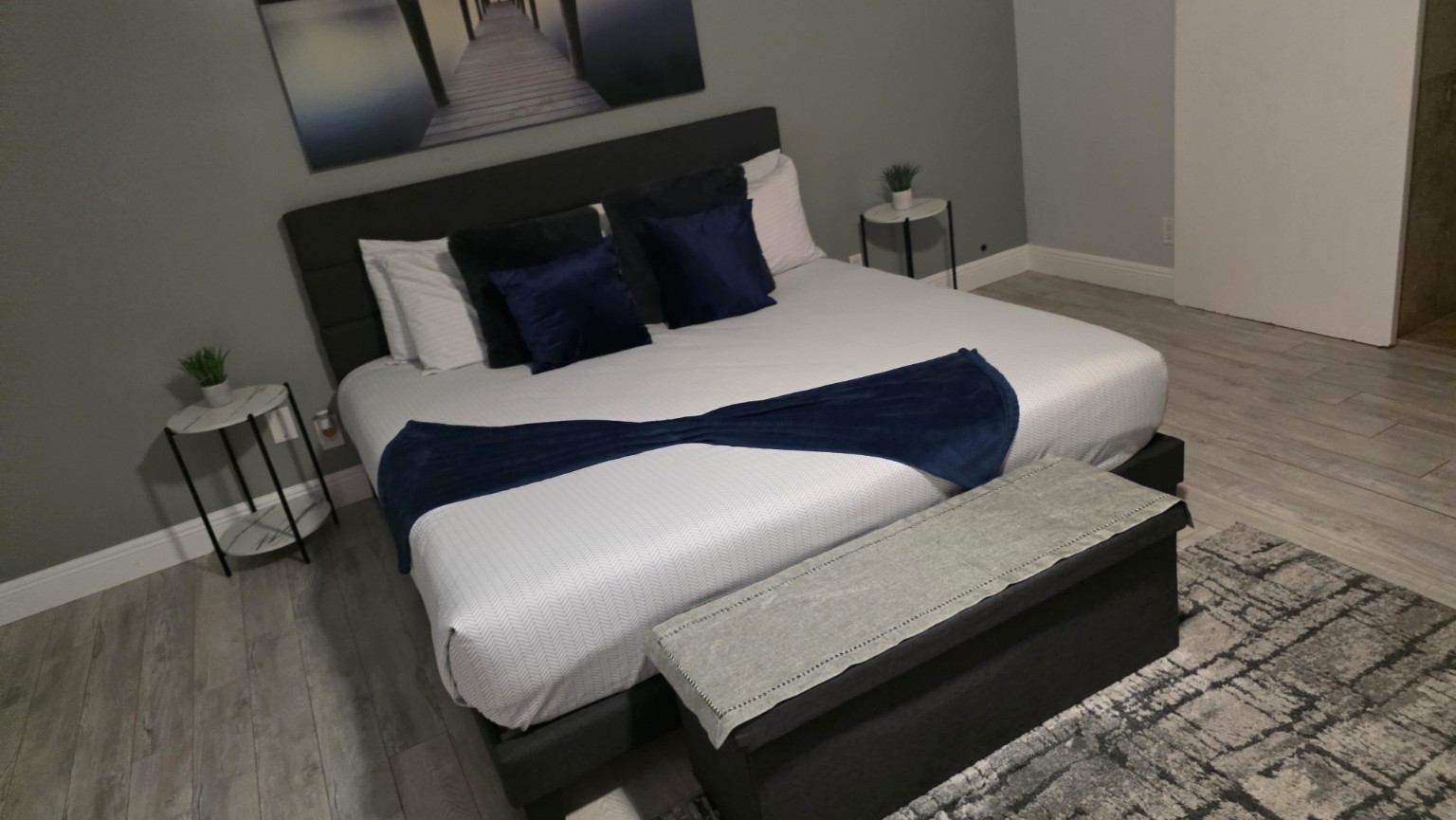 Elegant vacation-rental bedroom prepared in white and navy blue